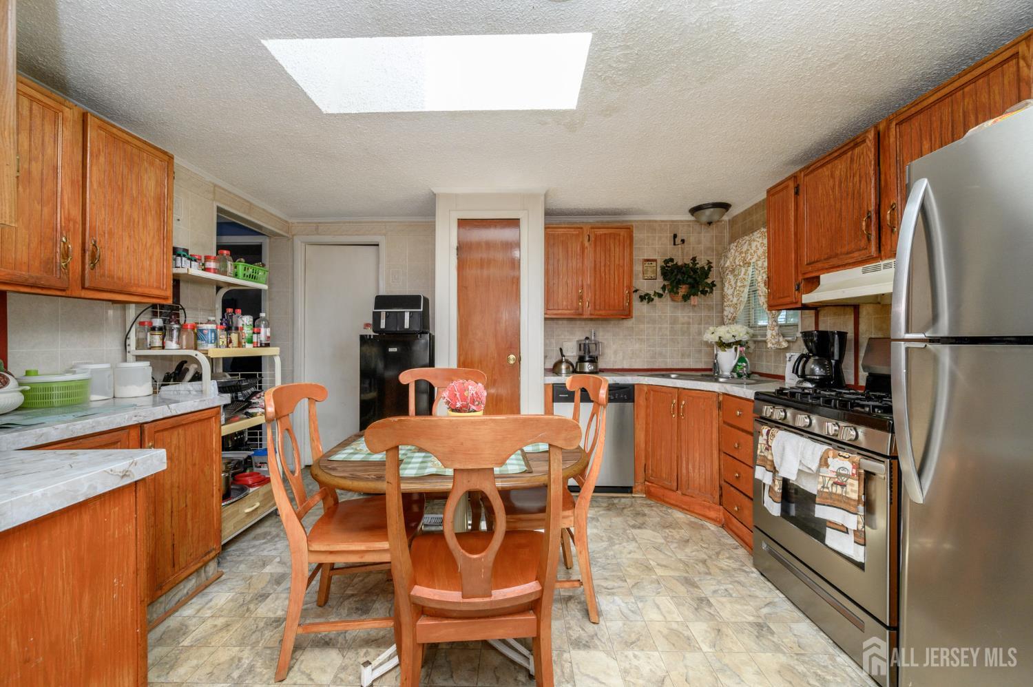8 Snow Chief Court Howell, NJ 07731 - Photo 9 of 26 a kitchen with a dining table chairs and a refrigerator
