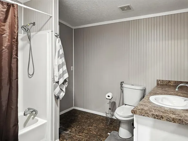a bathroom with a granite countertop sink toilet and shower