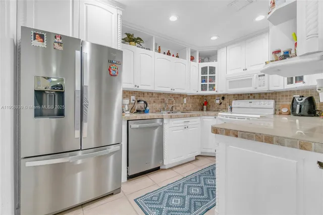 a kitchen with stainless steel appliances a refrigerator sink and cabinets