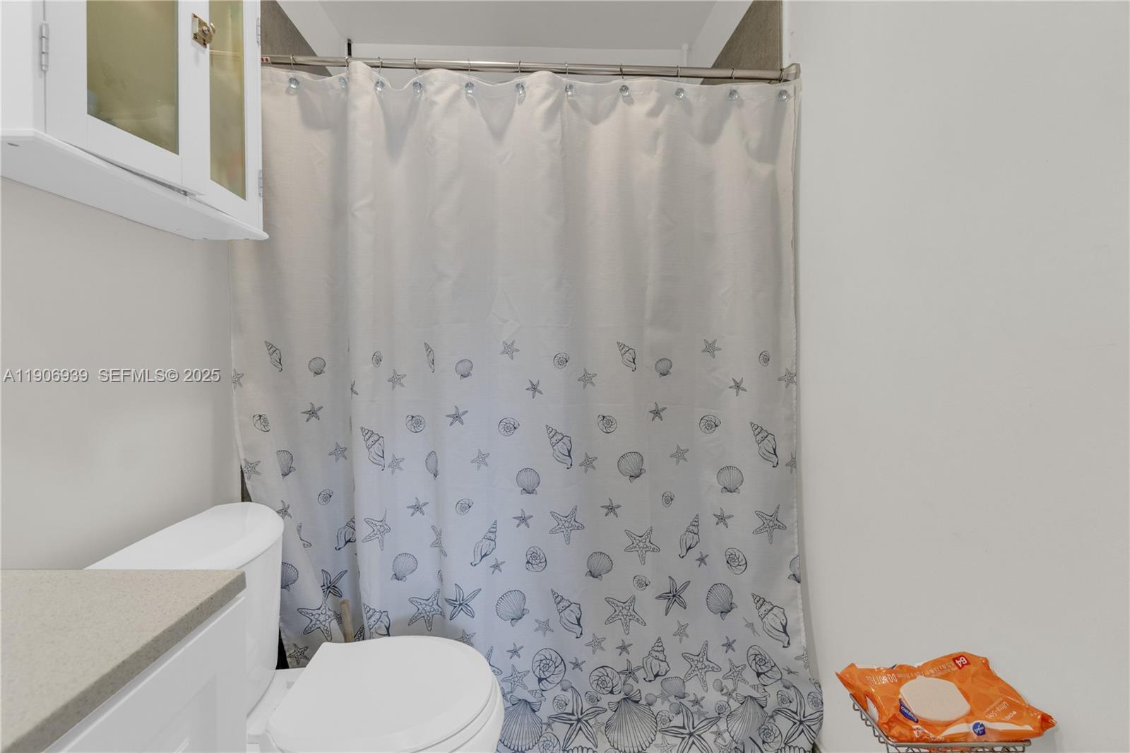 13715 Southwest 84th Street, Unit F Miami, FL 33143 - Photo 22 of 30 a white toilet sitting next to a shower curtain