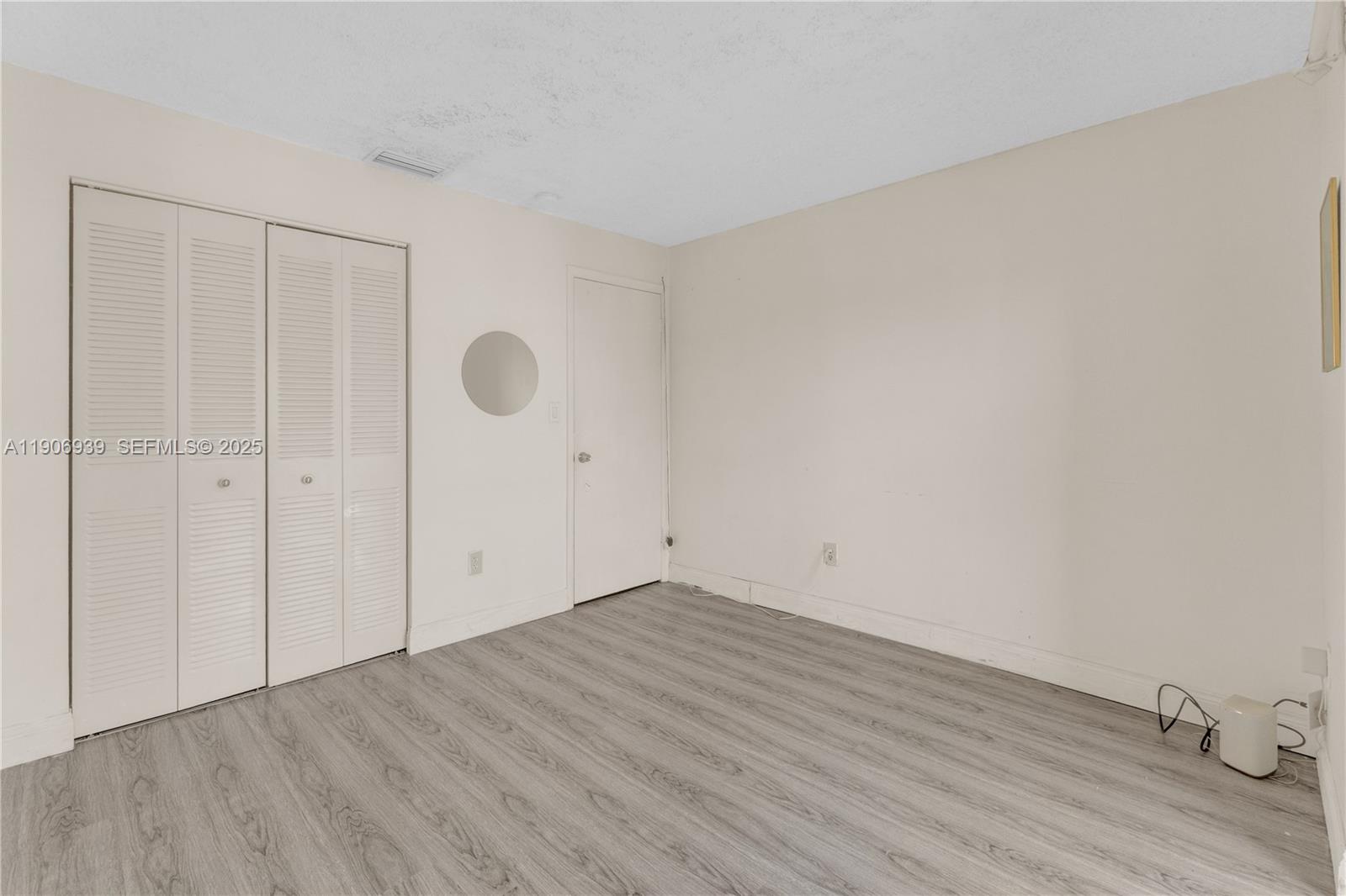 13715 Southwest 84th Street, Unit F Miami, FL 33143 - Photo 28 of 30 a view of an empty room with wooden floor