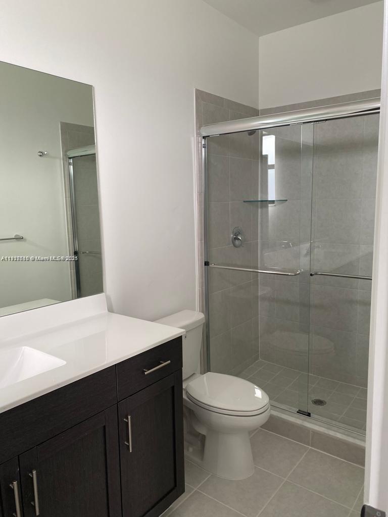 10166 Southwest 228th Terrace Miami, FL 33190 - Photo 20 of 29 a bathroom with a sink a toilet and shower