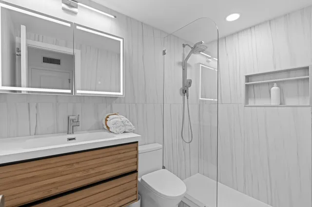 a bathroom with a sink a toilet and shower