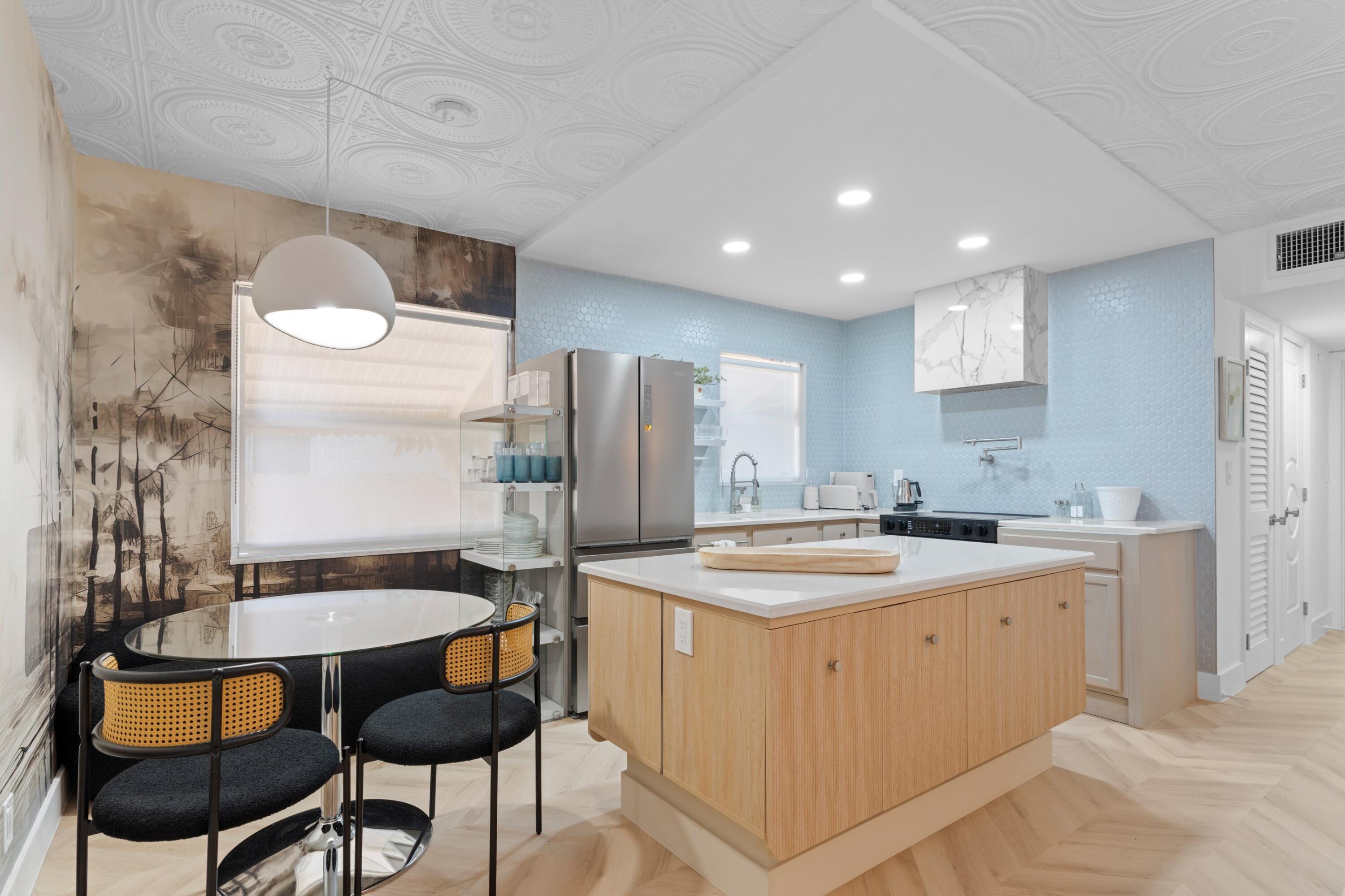 660 Glouchester Street, Unit 100 Boca Raton, FL 33487 - Photo 5 of 33 a kitchen with a table chairs sink and cabinets