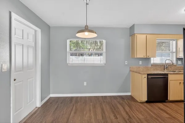 a view of an empty room with window and wooden floor