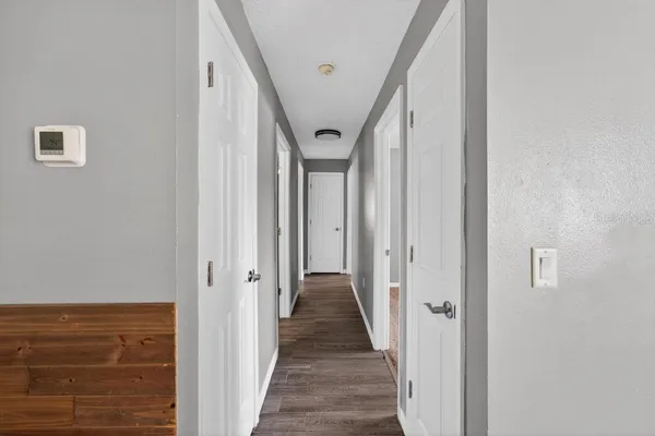 a view of a hallway with wooden floor and staircase