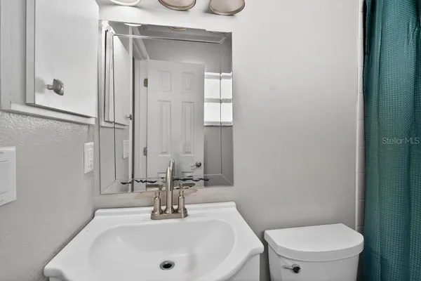 a bathroom with a sink a toilet and a mirror