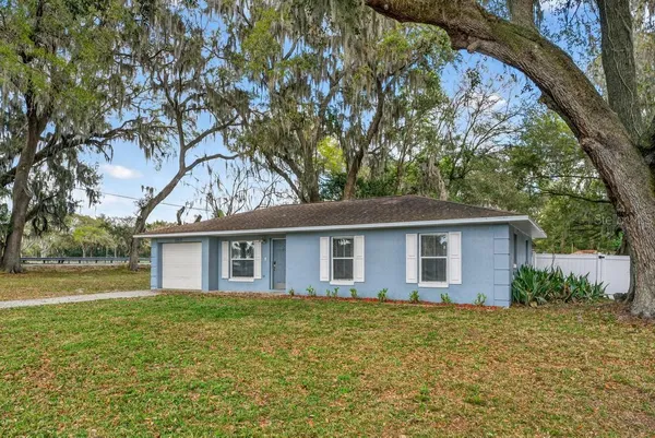 a front view of house with yard and trees around