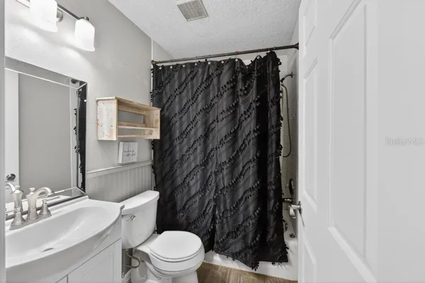 a bathroom with a sink toilet and mirror