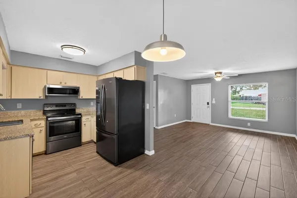 a kitchen with stainless steel appliances a refrigerator and a stove top oven