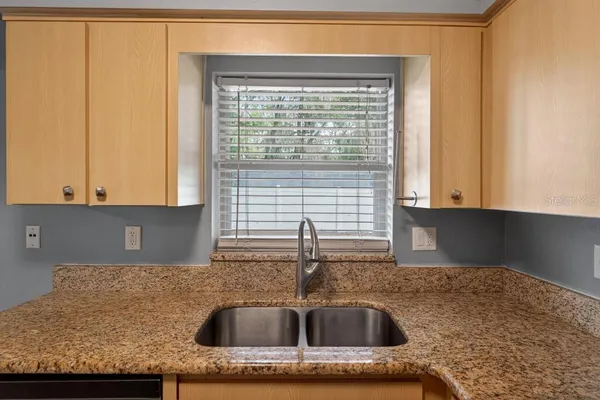 a kitchen with granite countertop sink and cabinets