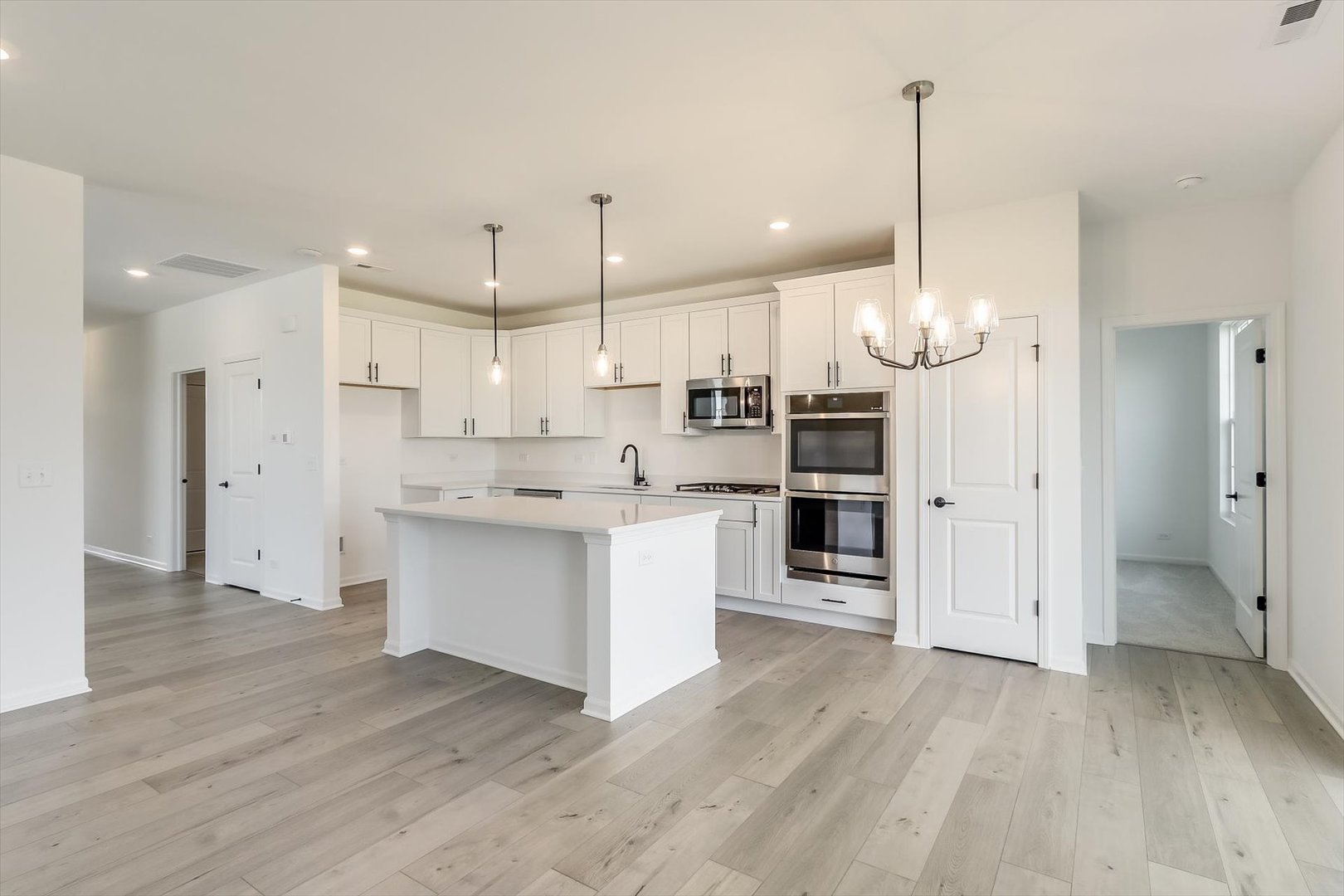730 Alberta Avenue Oswego, IL 60543 - Photo 13 of 29 a kitchen with stainless steel appliances kitchen island a refrigerator and a wooden floor