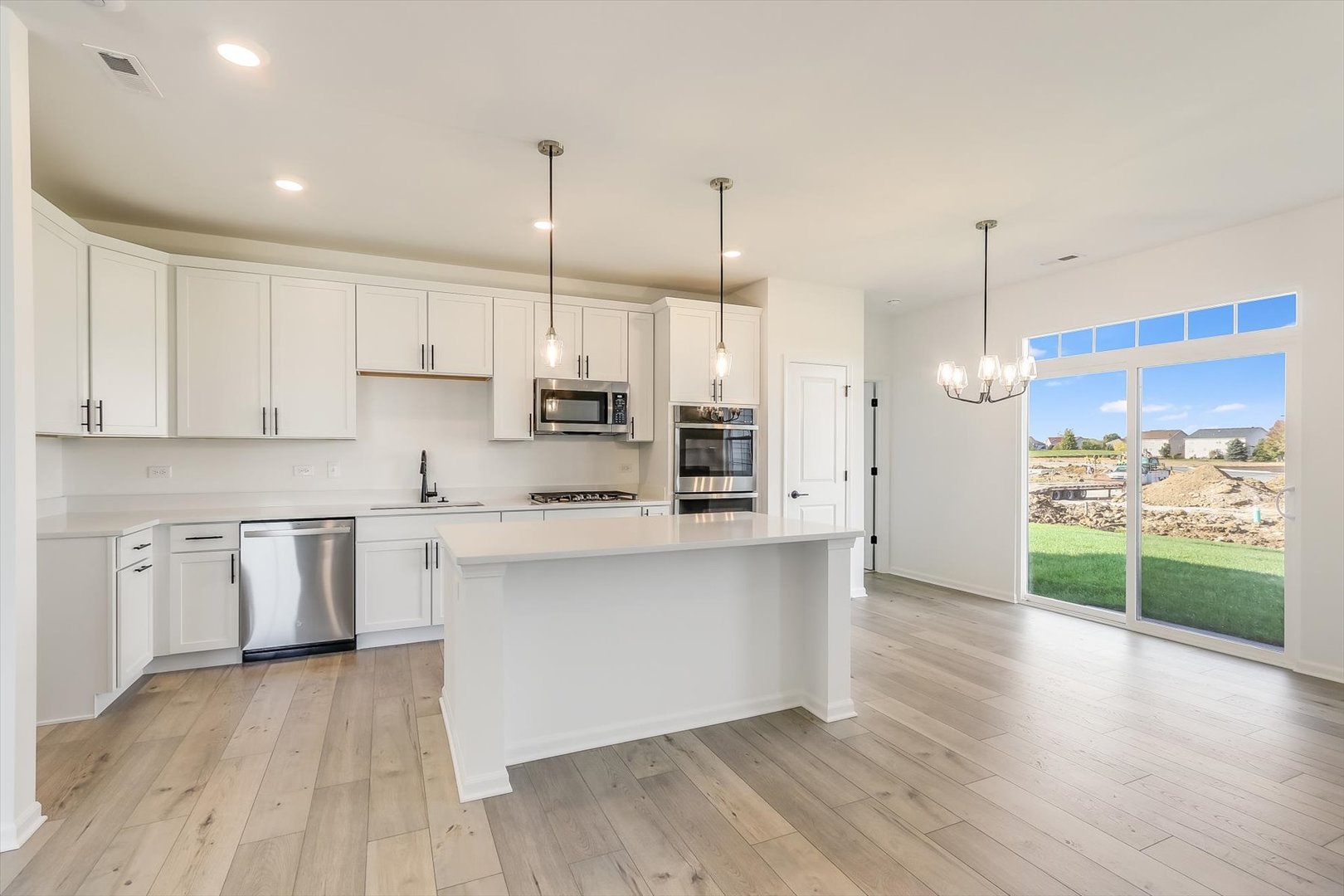 730 Alberta Avenue Oswego, IL 60543 - Photo 16 of 29 a kitchen with stainless steel appliances kitchen island wooden cabinets and wooden floor