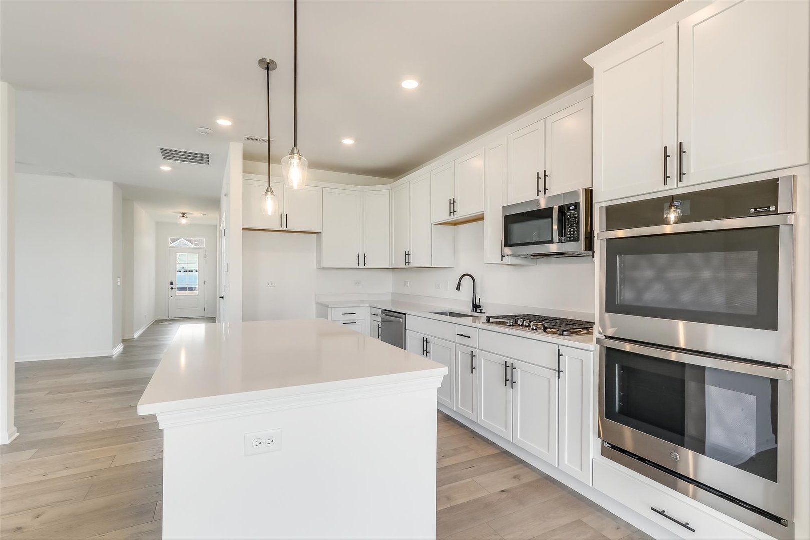 730 Alberta Avenue Oswego, IL 60543 - Photo 19 of 29 a kitchen with stainless steel appliances kitchen island a white counter space a sink and cabinets