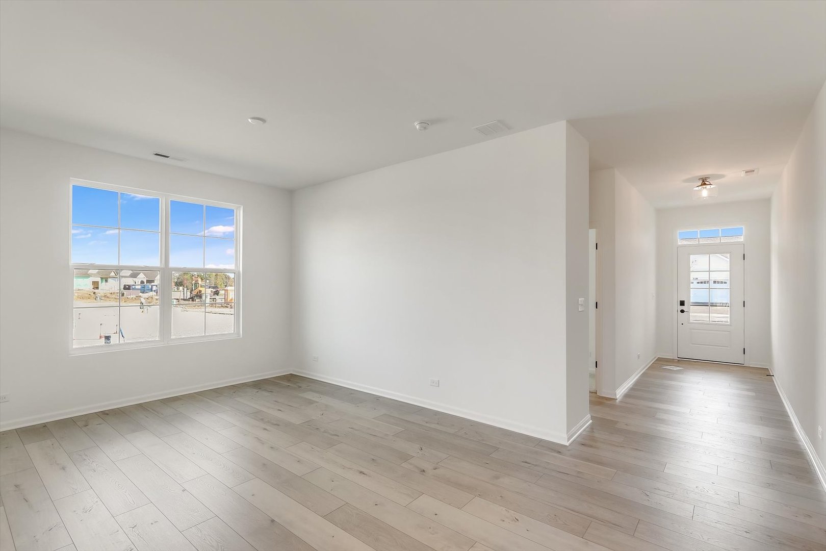 730 Alberta Avenue Oswego, IL 60543 - Photo 2 of 29 a view of an empty room with wooden floor and a window