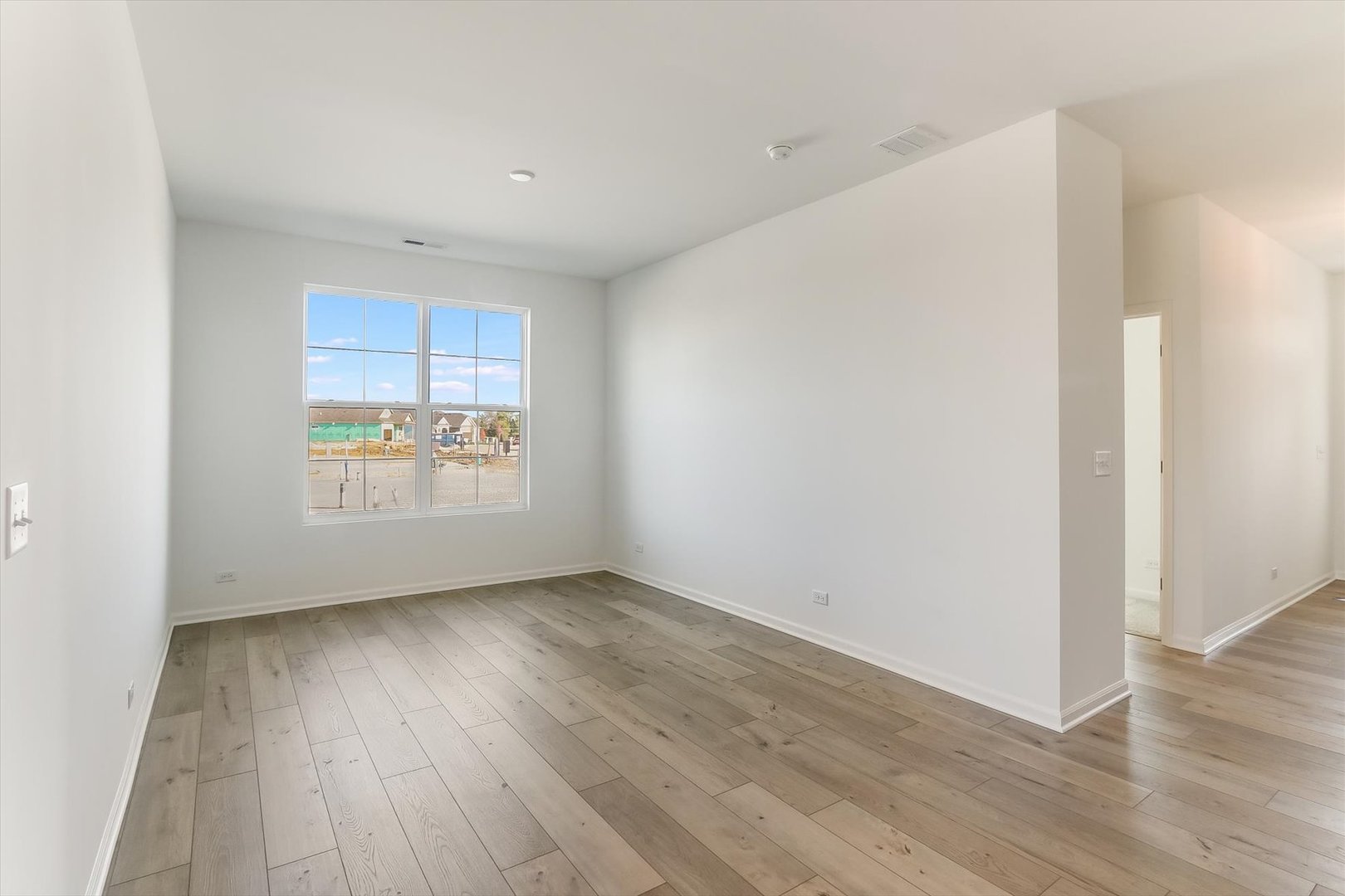 730 Alberta Avenue Oswego, IL 60543 - Photo 3 of 29 a view of an empty room with wooden floor and a window