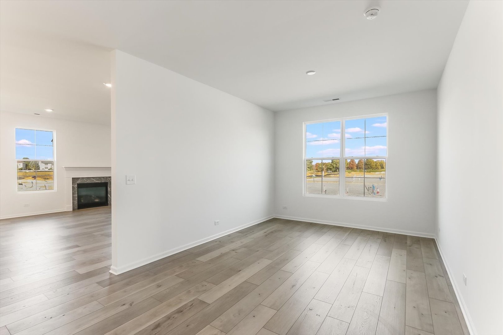 730 Alberta Avenue Oswego, IL 60543 - Photo 4 of 29 an empty room with wooden floor and windows