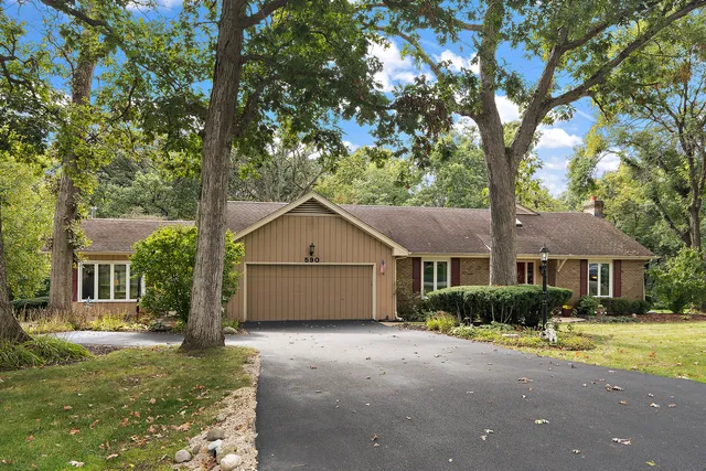 a view of a house with a tree in front of it