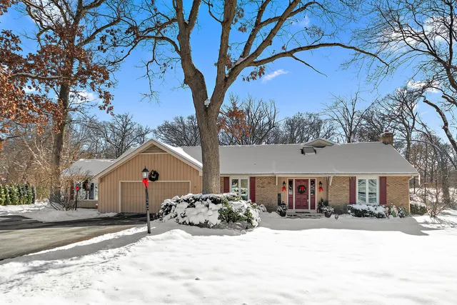 a front view of a house with a yard covered in snow