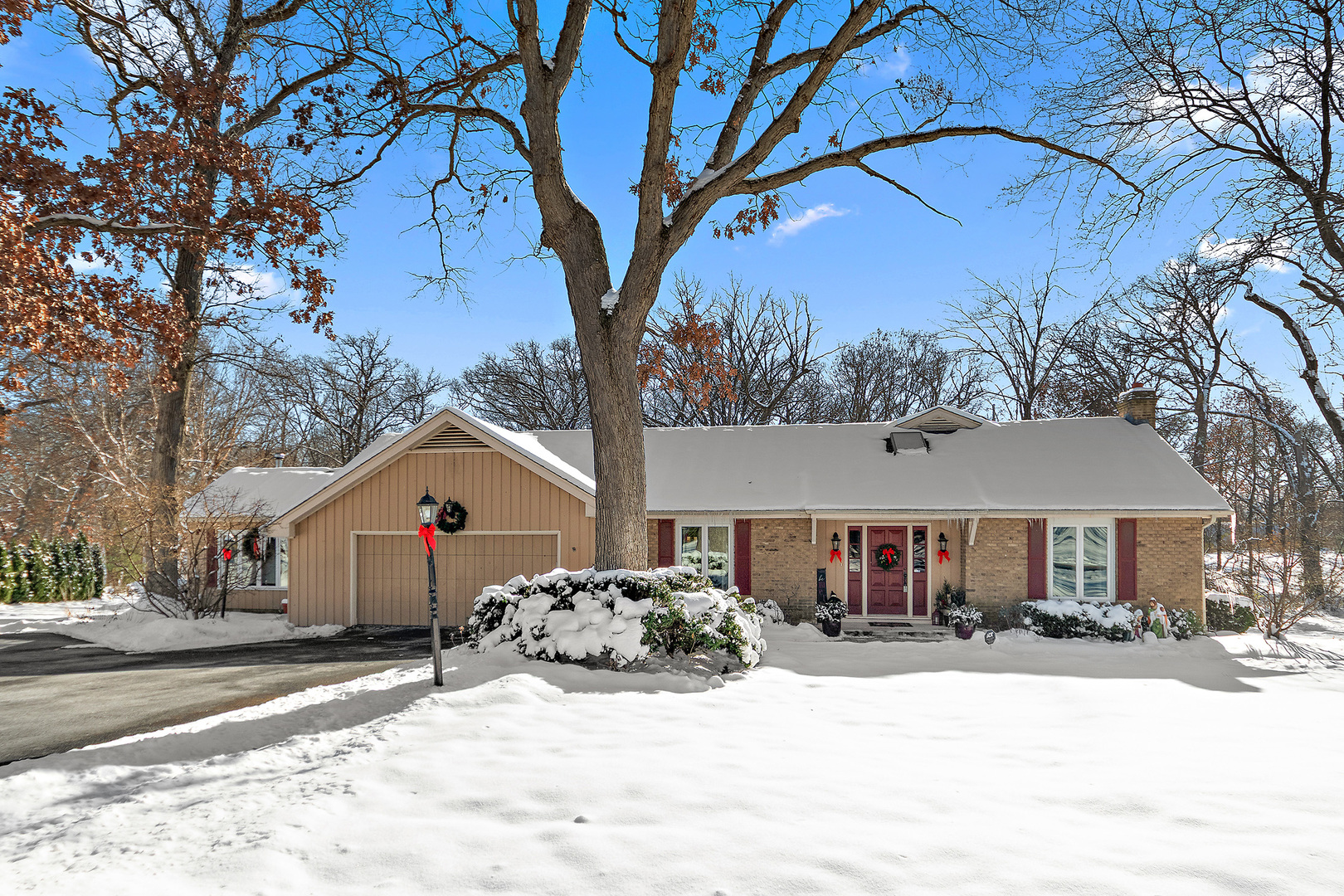a front view of a house with a yard covered in snow
