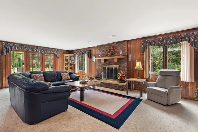 a living room with furniture a large window and a table
