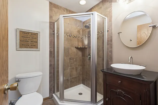 a bathroom with a toilet a sink and glass door