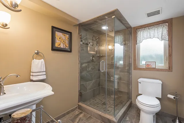 a bathroom with a shower a toilet and a sink