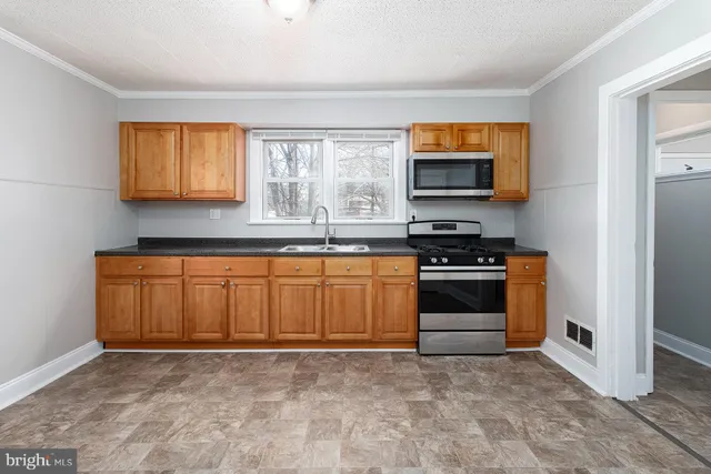 a kitchen with granite countertop a stove and a sink
