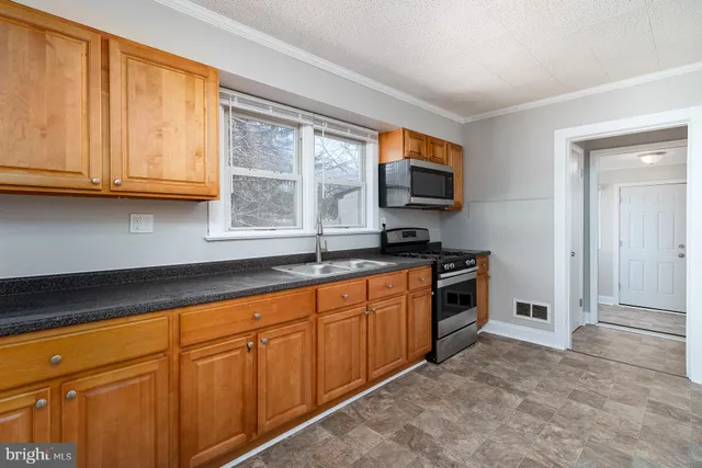 a kitchen with granite countertop a sink and a stove top oven