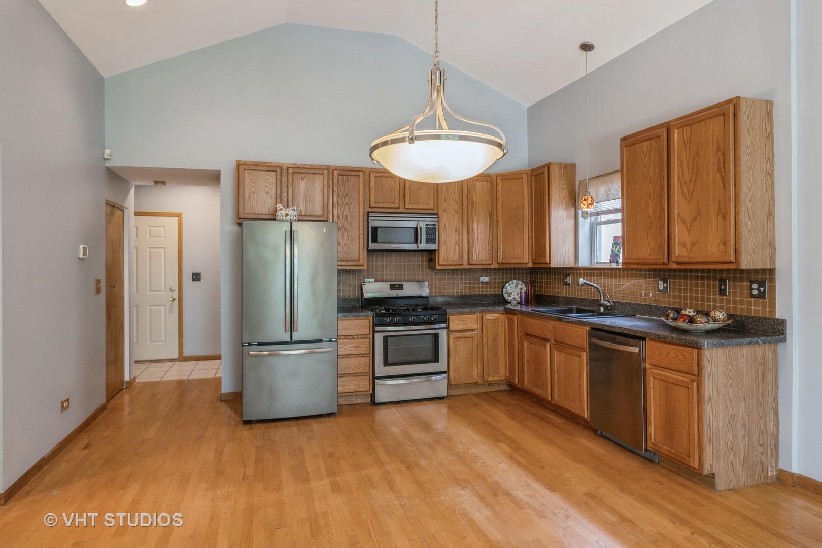 5931 West Huron Street, Unit 3N Chicago, IL 60644 - Photo 4 of 13 a kitchen with stainless steel appliances granite countertop a refrigerator a stove a sink and a microwave