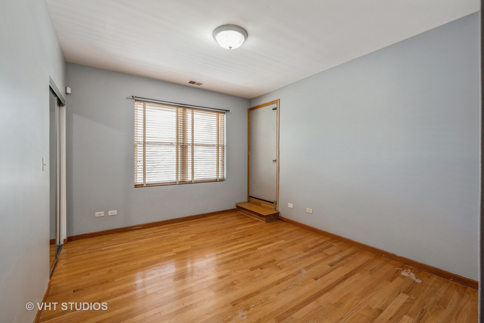 5931 West Huron Street, Unit 3N Chicago, IL 60644 - Photo 9 of 13 an empty room with wooden floor and windows