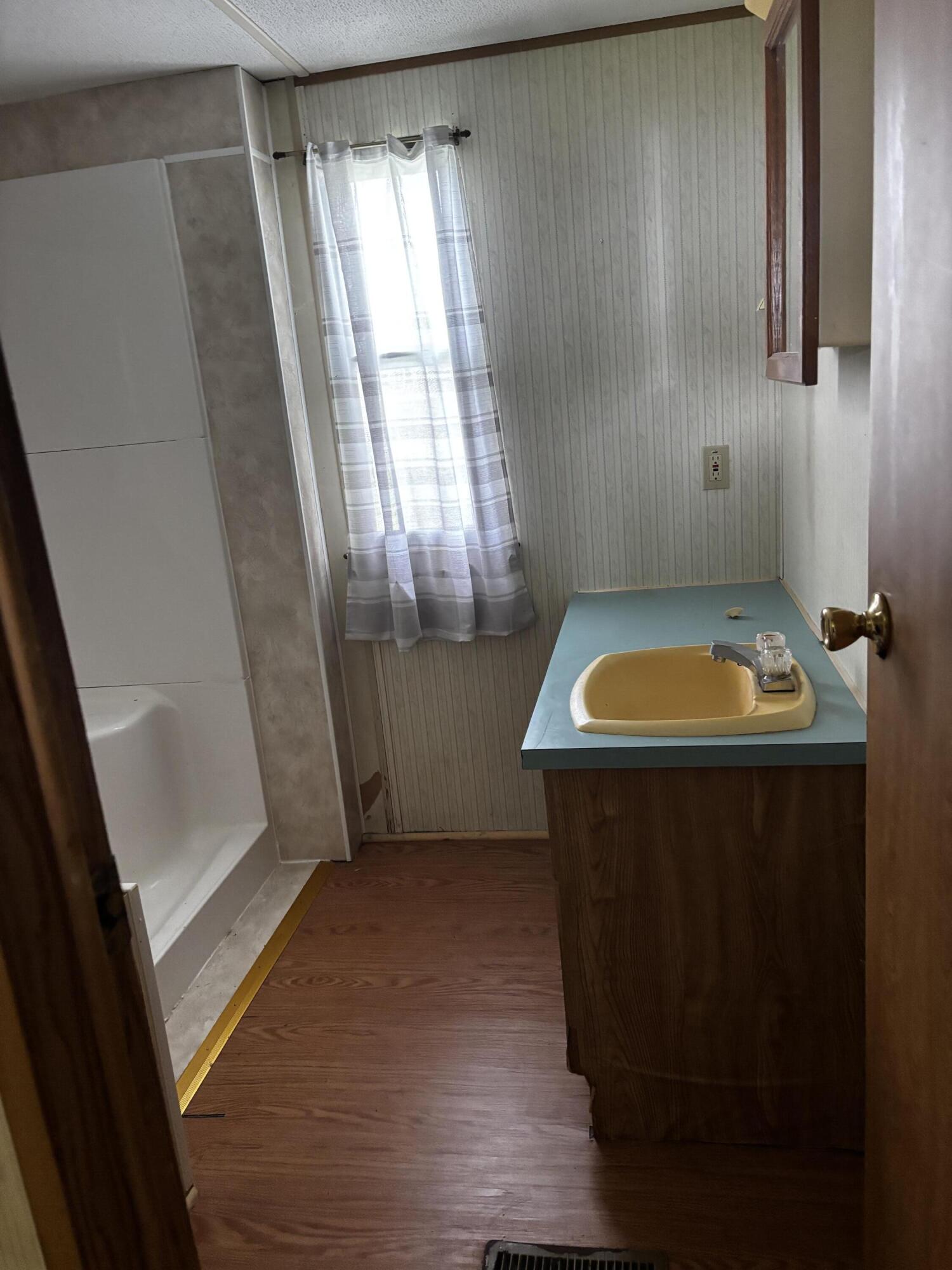 710 Commerce Avenue Iron Gate, VA 24448 - Photo 6 of 6 a bathroom with a sink a toilet a window and tub
