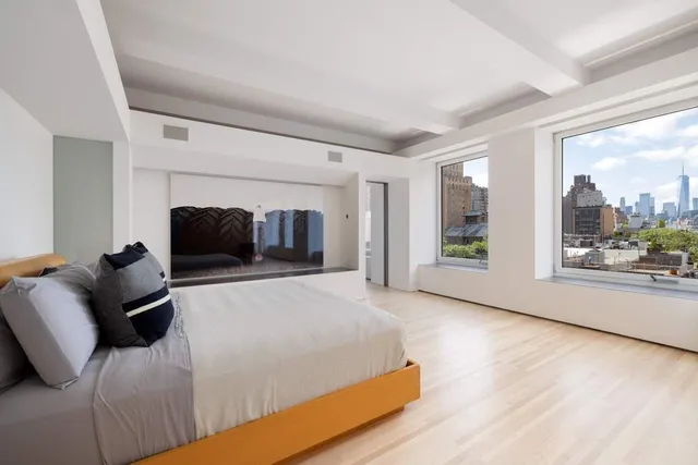 a bedroom with furniture and a large window