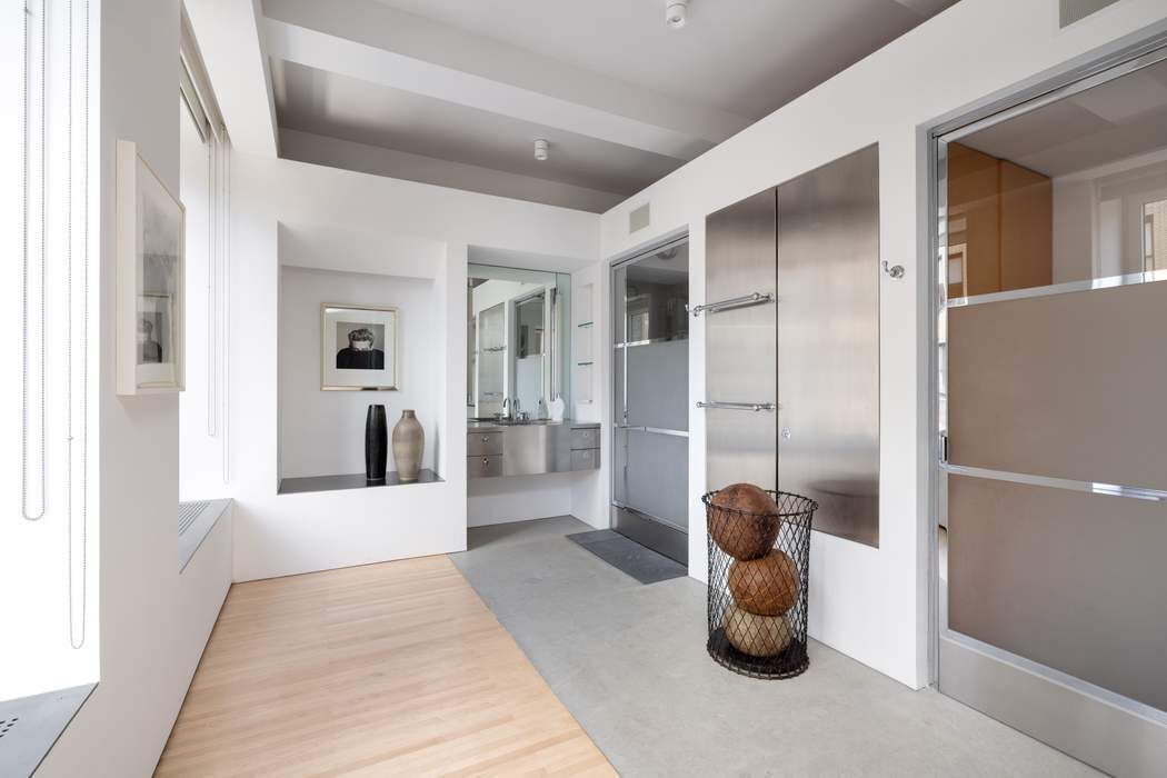 227 West 17th Street, Unit 7 Manhattan, NY 10011 - Photo 14 of 23 a view of a hallway with a couch and chandelier