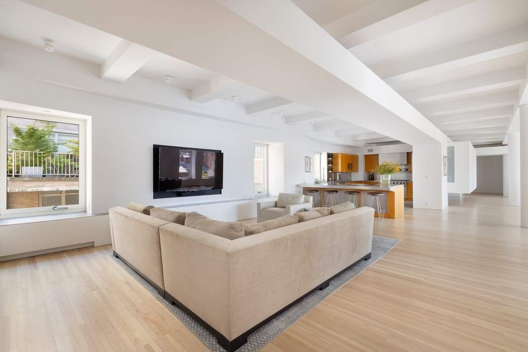 227 West 17th Street, Unit 7 Manhattan, NY 10011 - Photo 6 of 23 a living room with furniture and a flat screen tv