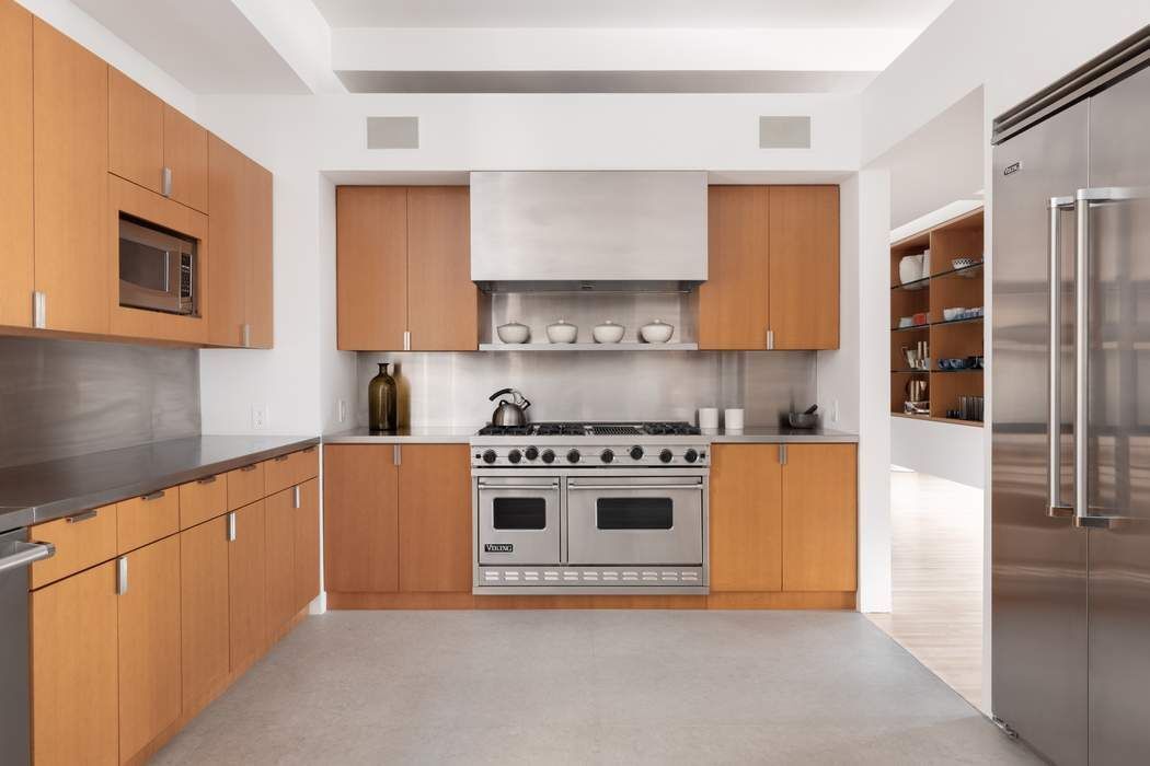 227 West 17th Street, Unit 7 Manhattan, NY 10011 - Photo 8 of 23 a kitchen with stainless steel appliances granite countertop a stove and a refrigerator