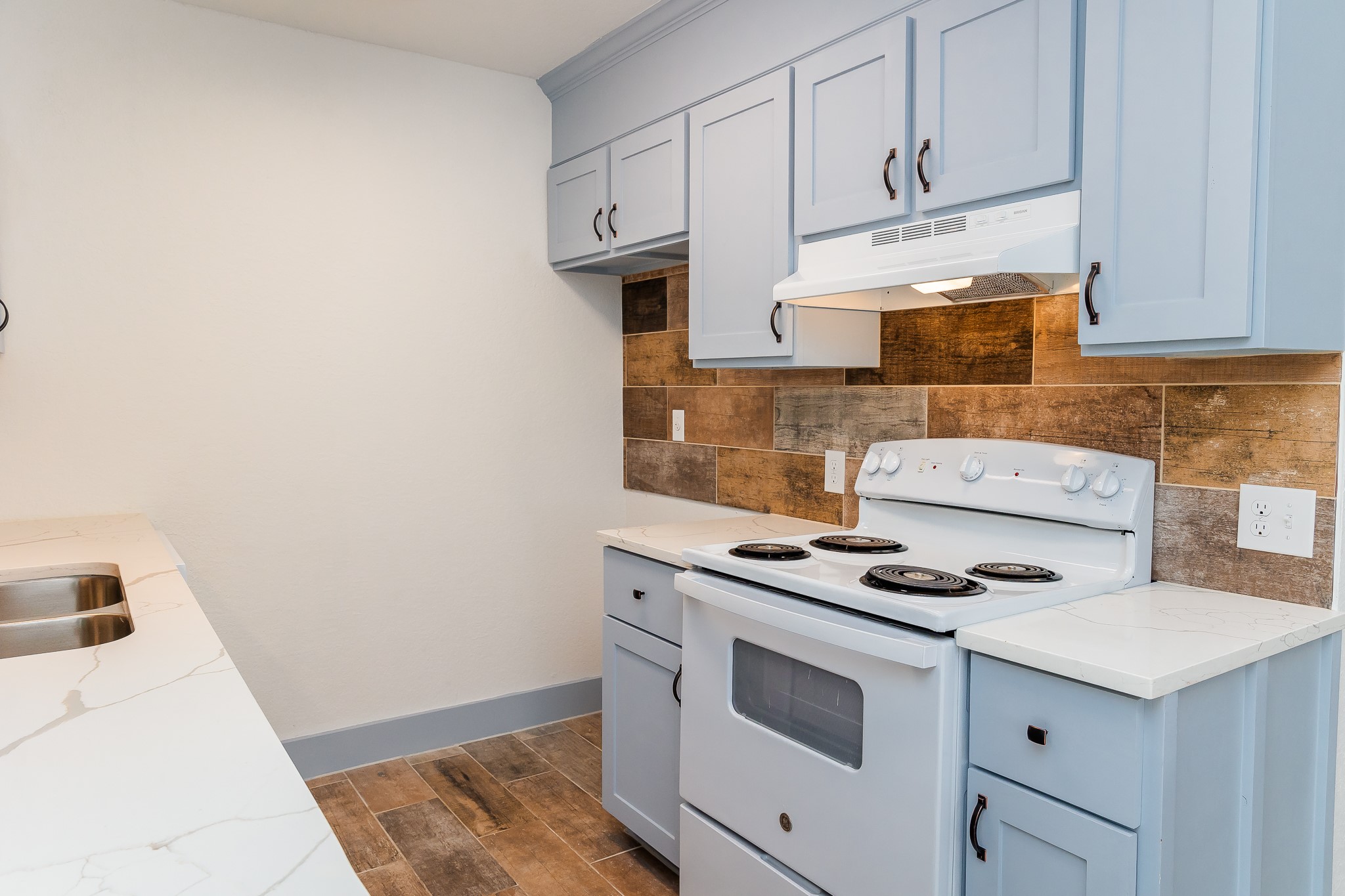 811 Matchett Street Brenham, TX 77833 - Photo 6 of 18 a kitchen with granite countertop a sink a stove and cabinets