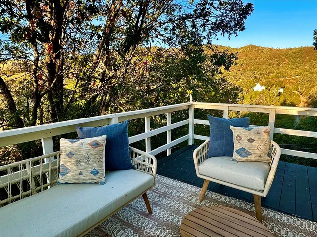 a balcony with wooden floor and outdoor seating
