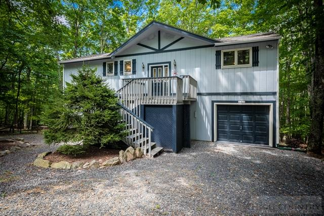 605 Pine Ridge Road Beech Mountain, NC 28604 - Photo 1 of 45 a front view of a house with a yard and garage