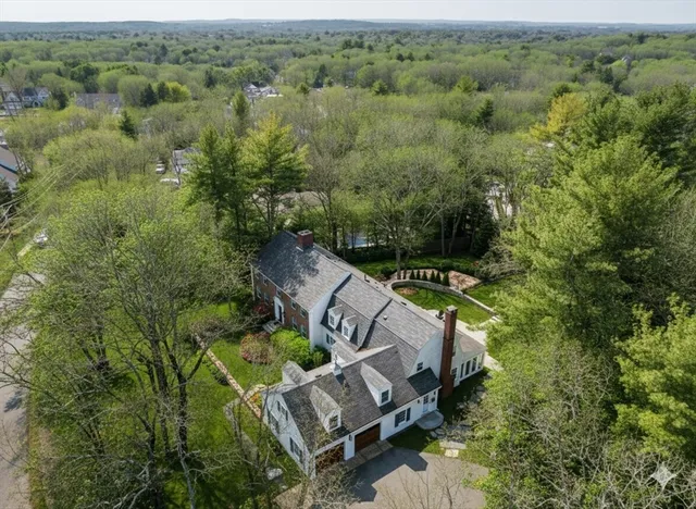 a view of a brick building next to a yard with large trees