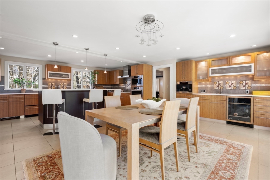 84 Royalston Road Wellesley, MA 02481 - Photo 22 of 42 a dining room with stainless steel appliances kitchen island granite countertop a table chairs and a view of kitchen