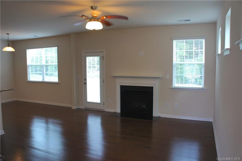 78194 Rillstone Drive, Unit 226 Lancaster, SC 29720 - Photo 4 of 19 a view of an empty room with wooden floor fireplace and a window