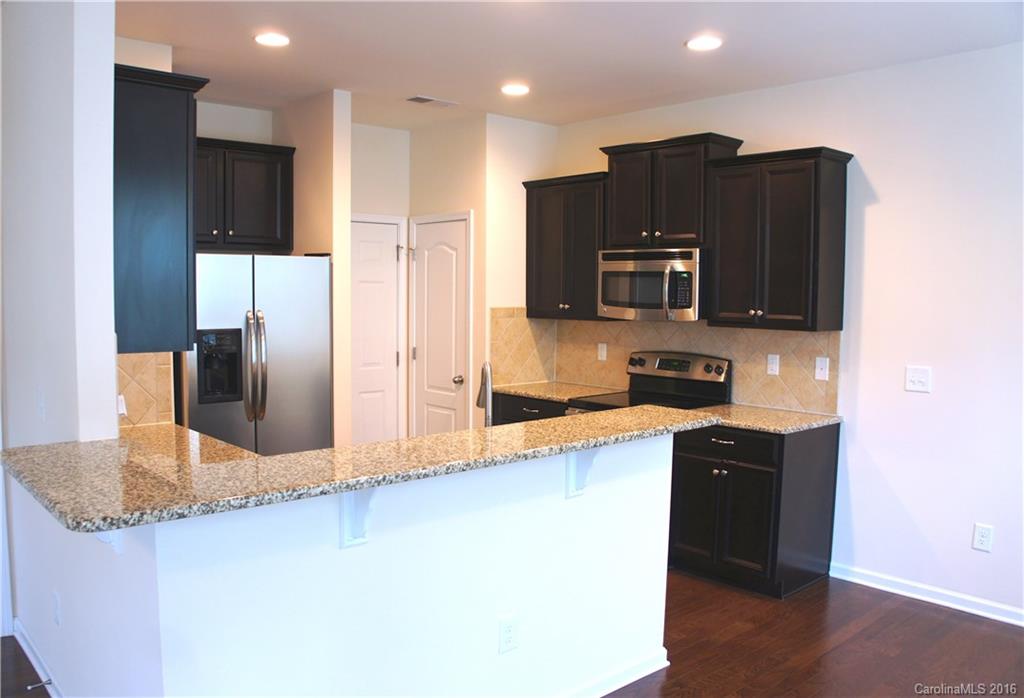 78194 Rillstone Drive, Unit 226 Lancaster, SC 29720 - Photo 6 of 19 a kitchen with stainless steel appliances granite countertop a refrigerator a stove a sink and a microwave