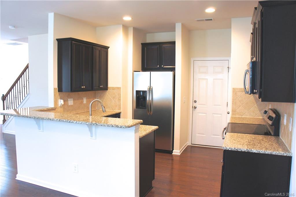 78194 Rillstone Drive, Unit 226 Lancaster, SC 29720 - Photo 7 of 19 a kitchen with stainless steel appliances granite countertop a refrigerator a sink and a stove