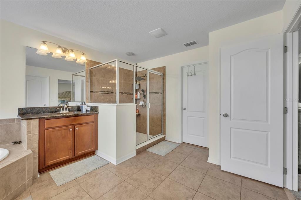 4277 Bugle Street Clermont, FL 34711 - Photo 26 of 35 a large bathroom with a granite countertop sink mirror and shower