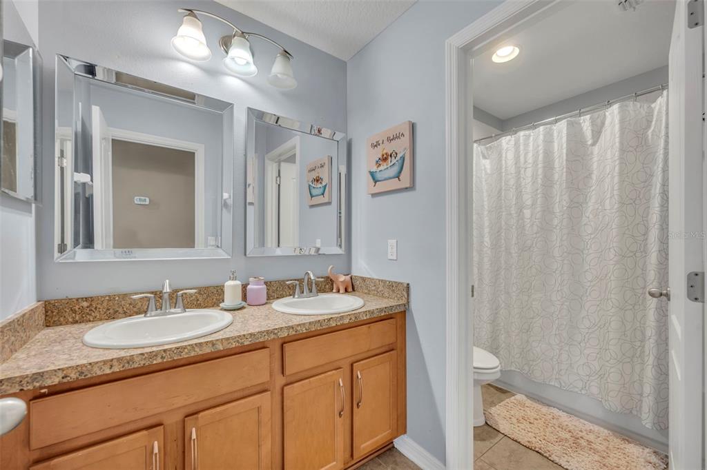 4277 Bugle Street Clermont, FL 34711 - Photo 29 of 35 a bathroom with a granite countertop sink toilet and shower