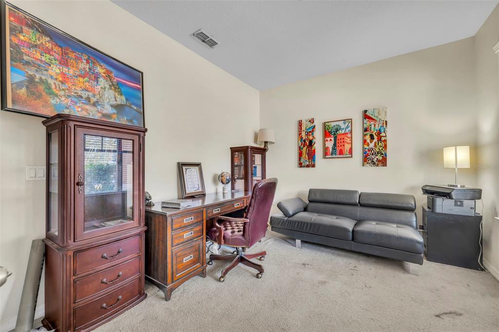 4277 Bugle Street Clermont, FL 34711 - Photo 5 of 35 a living room with furniture a couch and a bookshelf