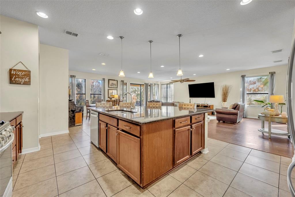 4277 Bugle Street Clermont, FL 34711 - Photo 10 of 35 a kitchen with stainless steel appliances kitchen island granite countertop a sink and a stove