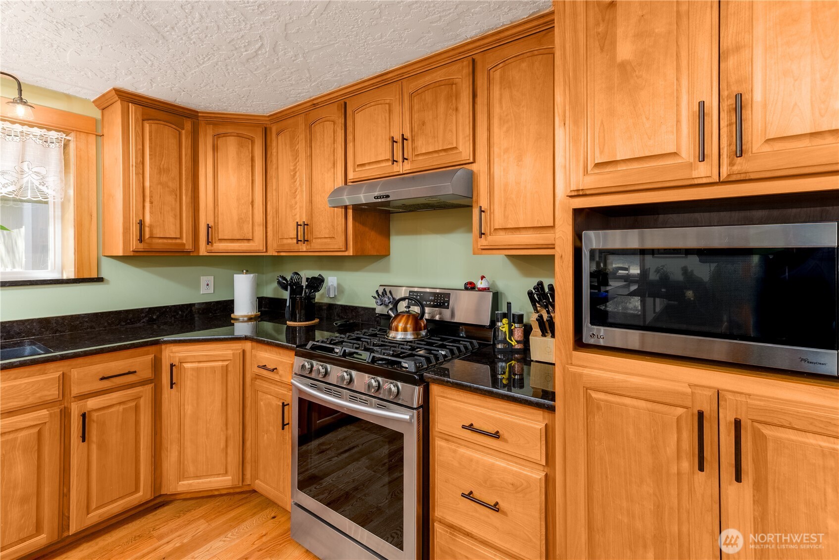 273702 Highway 101 Sequim, WA 98382 - Photo 11 of 40 a kitchen with stainless steel appliances granite countertop a stove a sink and a microwave