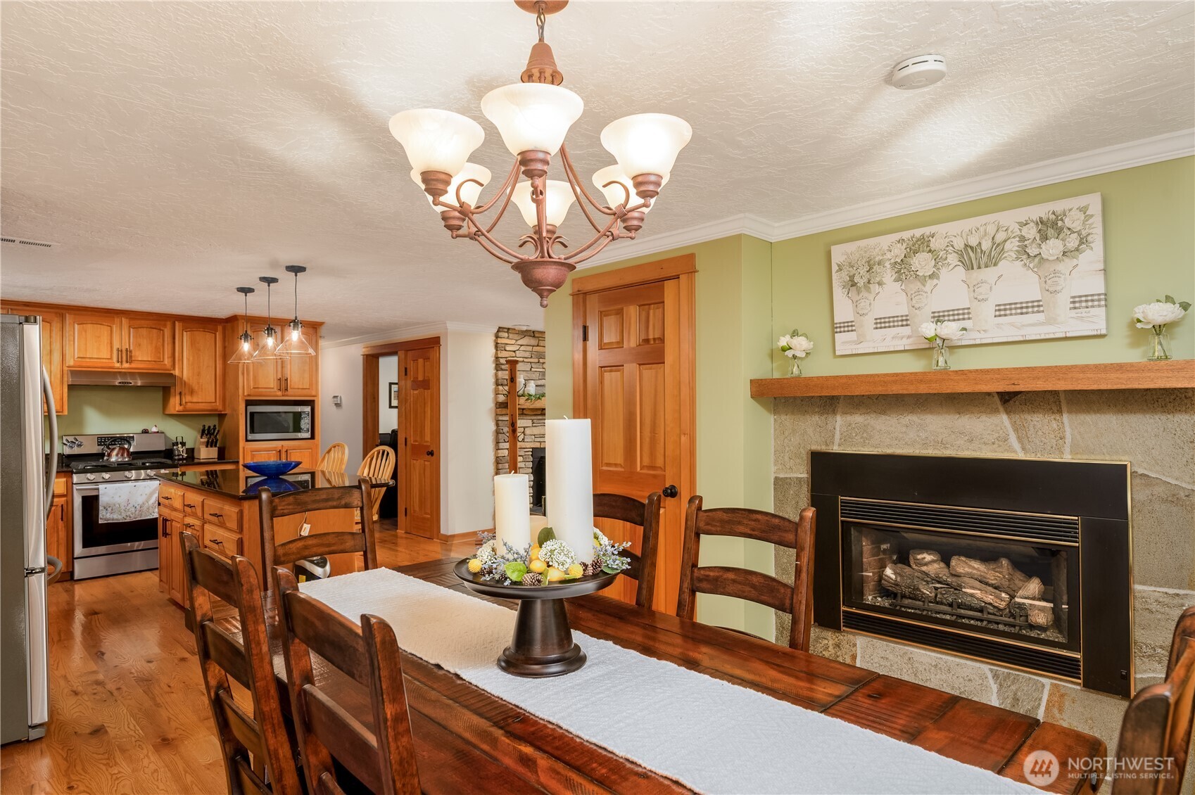 273702 Highway 101 Sequim, WA 98382 - Photo 8 of 40 a view of a dining room with furniture wooden floor fireplace and chandelier